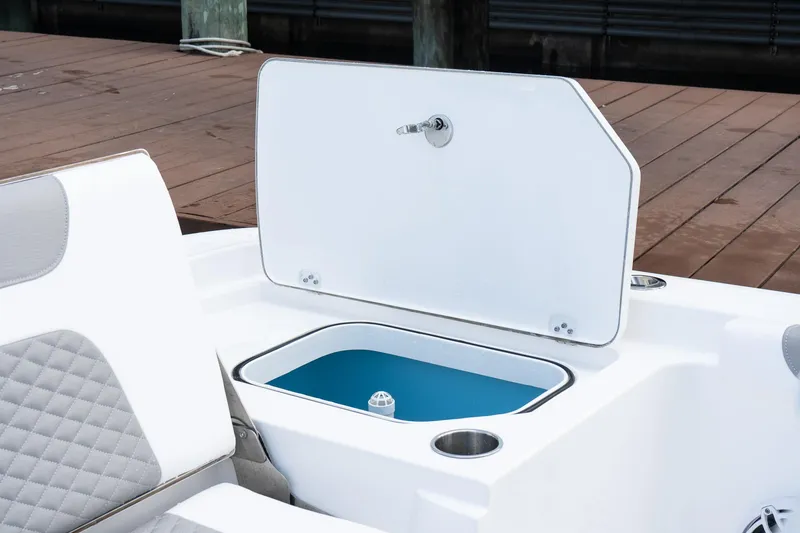 Slide: The Image of 2025 Caymas 291 HB boat with open storage compartment and cushioned seating. - 9