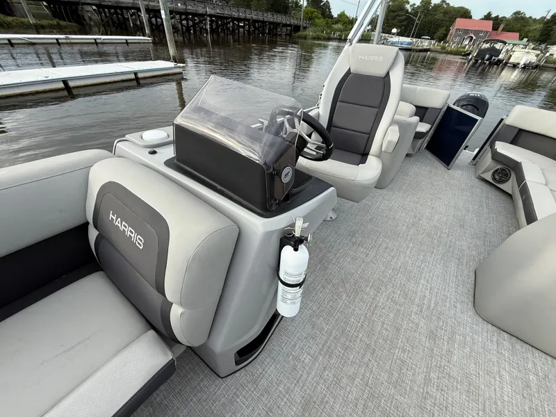 Slide: The Image of 2024 Harris Cruiser 230 pontoon boat interior with seating and steering console. - 10