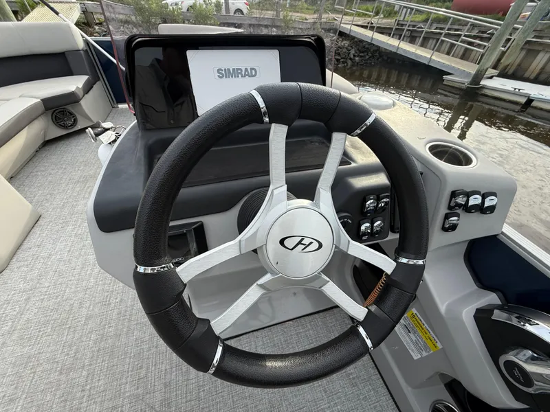 Slide: The Image of 2024 Harris Cruiser 230 steering wheel and dashboard with Simrad display. - 12