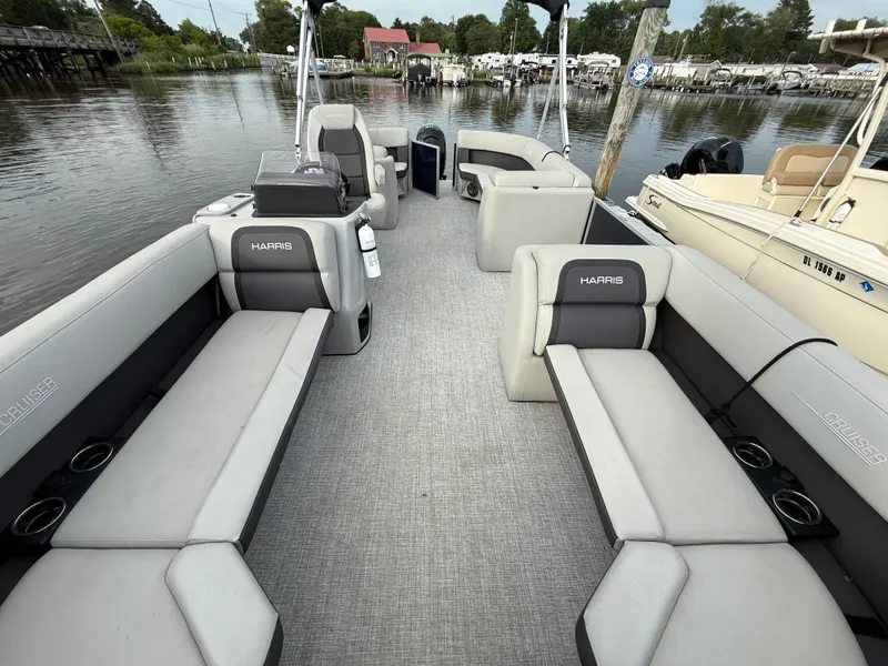 Slide: The Image of 2024 Harris Cruiser 230 pontoon boat interior with spacious seating and scenic waterfront view. - 9