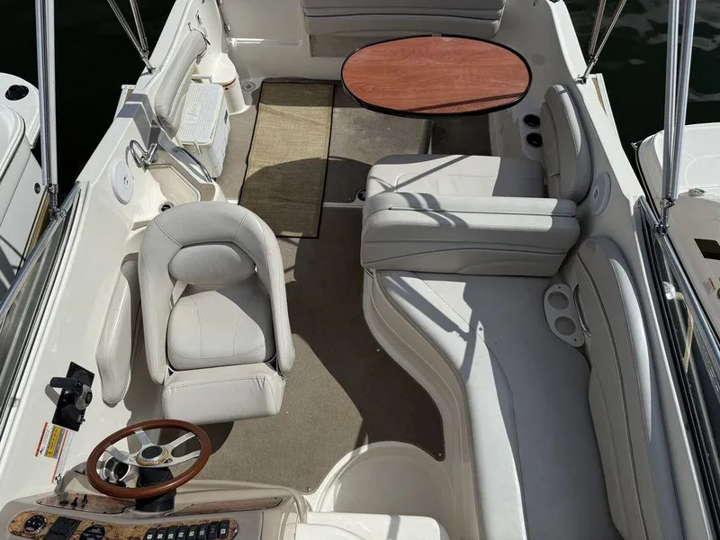 Slide: The Image of 2006 Larson 240 Cabrio boat interior with seating, table, and steering wheel. - 11