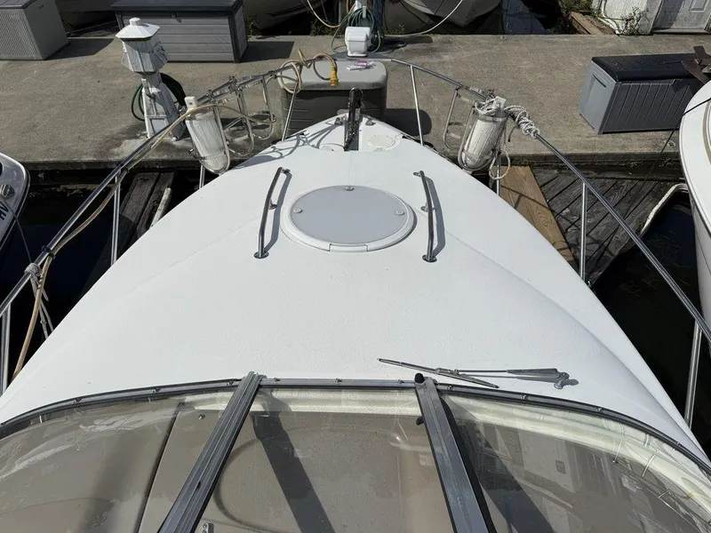 Slide: The Image of 2006 Larson 240 Cabrio boat docked, showing bow and deck details. - 12