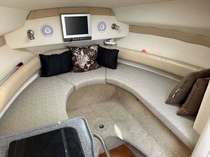 Slide: The Image of Interior of 2006 Larson 240 Cabrio boat with seating, pillows, and a mounted TV. - 14