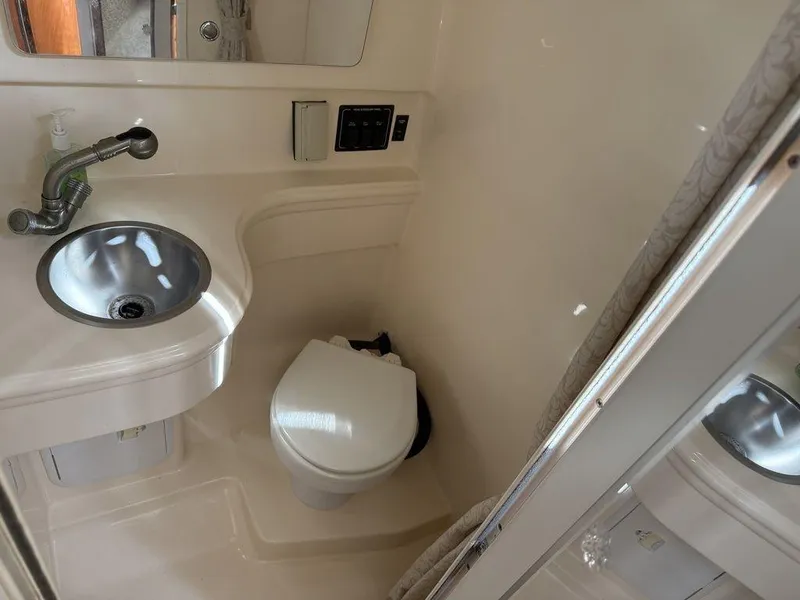 Slide: The Image of Compact bathroom in 2006 Larson 240 Cabrio boat with sink and toilet. - 15
