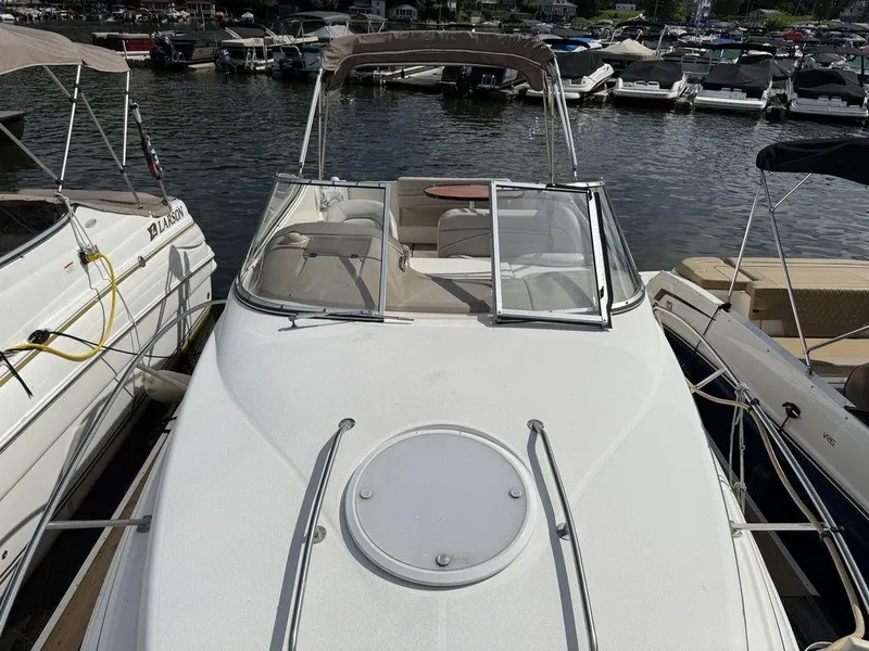 Slide: The Image of 2006 Larson 240 Cabrio boat docked at marina, surrounded by other vessels. - 16