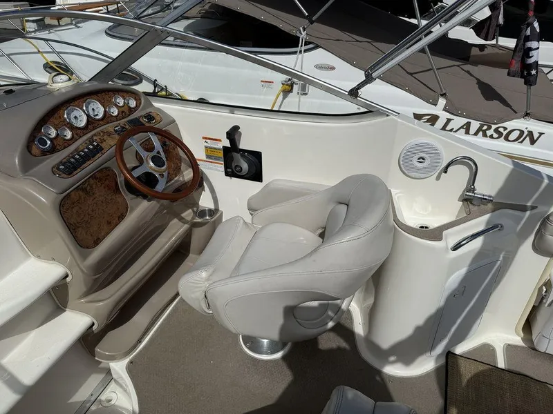 Slide: The Image of 2006 Larson 240 Cabrio boat interior with steering wheel, dashboard, and seating area. - 4