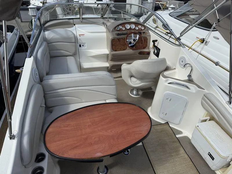 Slide: The Image of 2006 Larson 240 Cabrio boat interior with seating, table, and helm. - 5