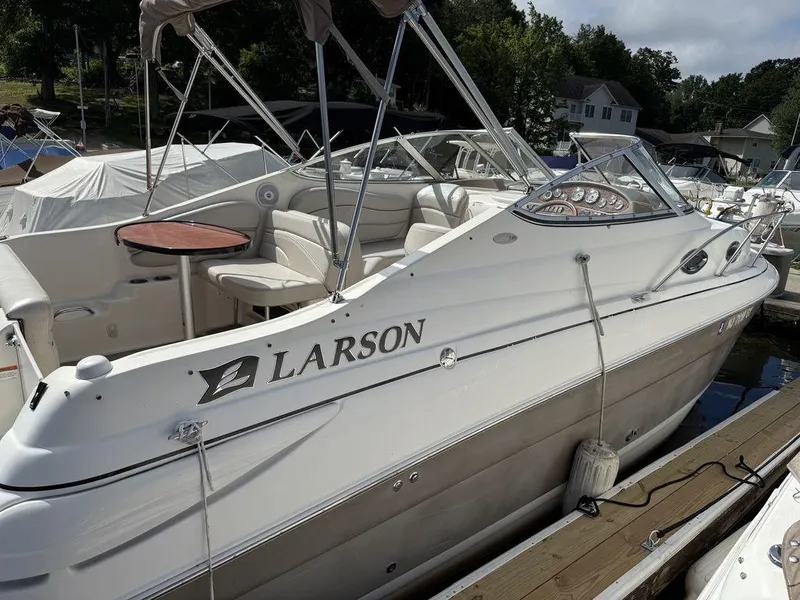 Slide: The Image of 2006 Larson 240 Cabrio boat docked, featuring sleek design and comfortable seating. - 8