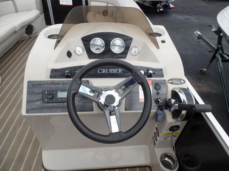 Slide: The Image of 2018 Harris Cruiser 240 boat dashboard with steering wheel, gauges, and controls. - 11