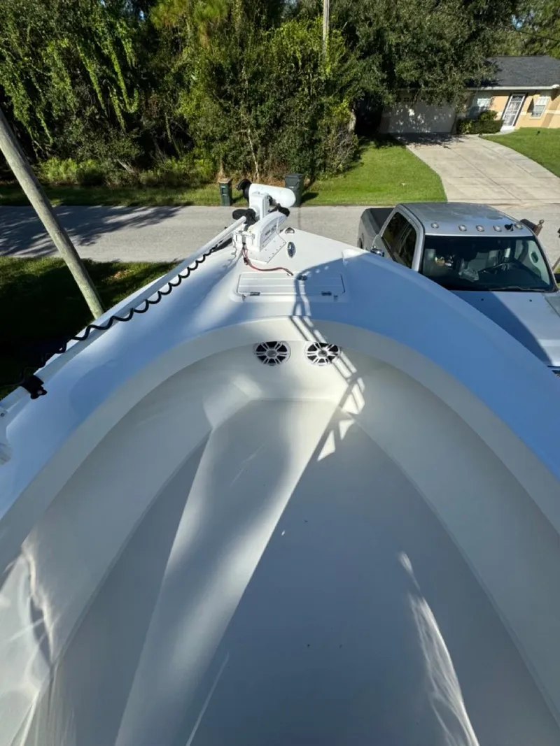 Slide: The Image of 2022 Parker 2300 Special Edition boat bow with trolling motor, parked near a driveway. - 5