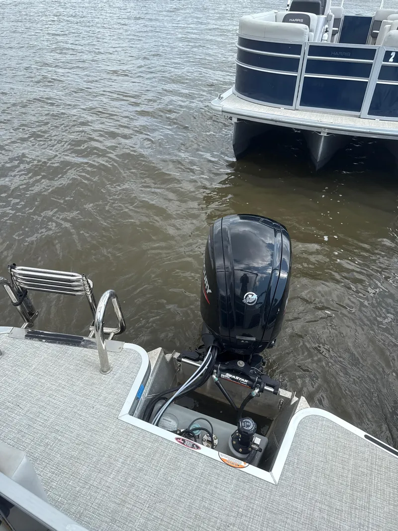 Slide: The Image of 2024 Harris Cruiser 230 pontoon boat with outboard motor on water. - 8