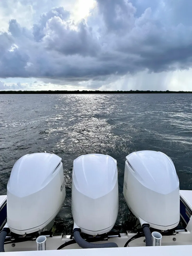 Slide: The Image of 2018 Pursuit S 368 Sport boat engines against a cloudy sky over water. - 14