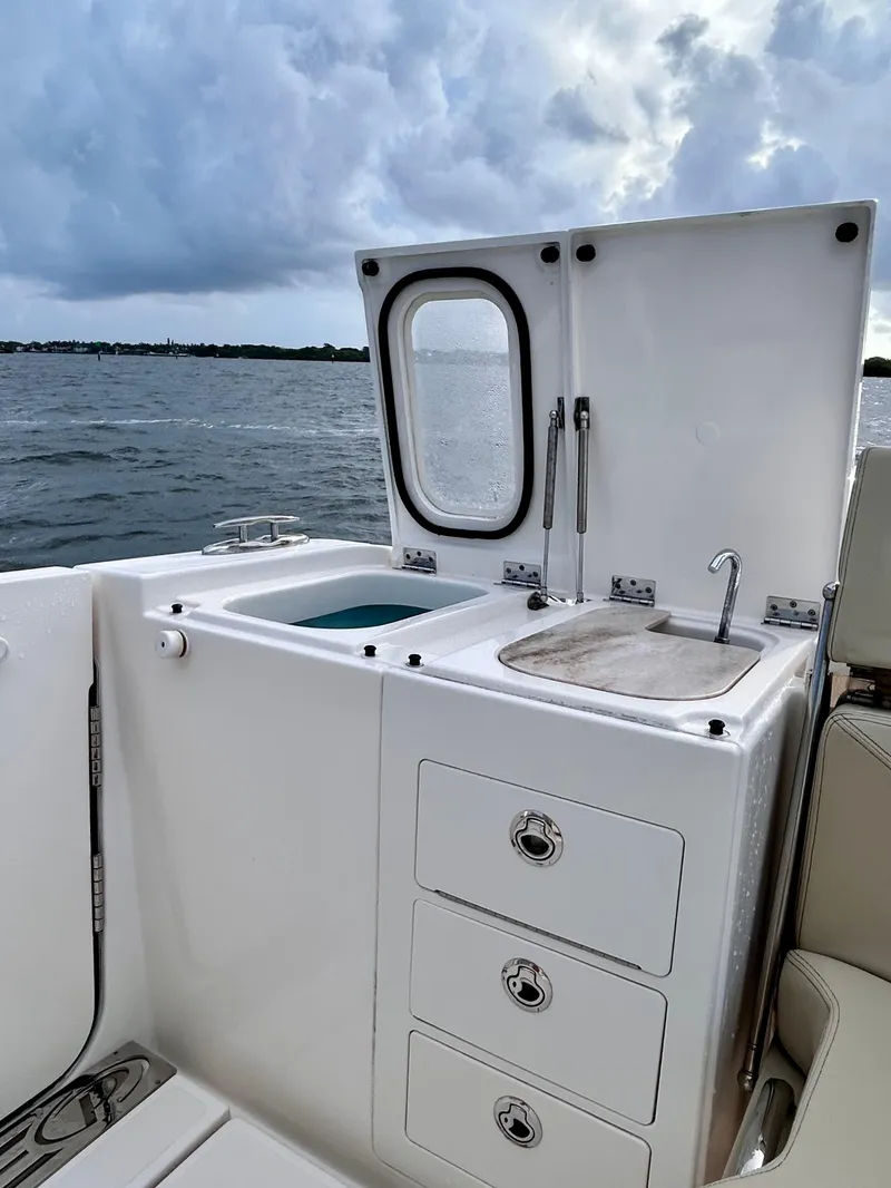 Slide: The Image of 2018 Pursuit S 368 Sport boat with sink and storage, ocean view in background. - 15