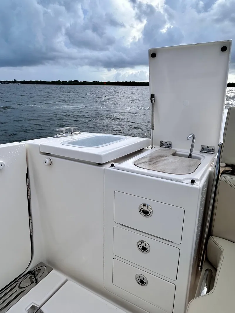 Slide: The Image of 2018 Pursuit S 368 Sport boat with sink and storage, ocean view in background. - 16