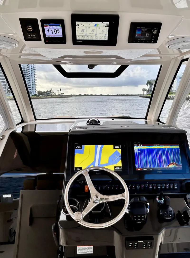 Slide: The Image of 2018 Pursuit S 368 Sport boat dashboard with navigation screens and steering wheel. - 2
