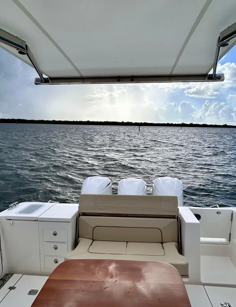 Slide: The Image of 2018 Pursuit S 368 Sport boat interior with seating, table, and ocean view. - 21