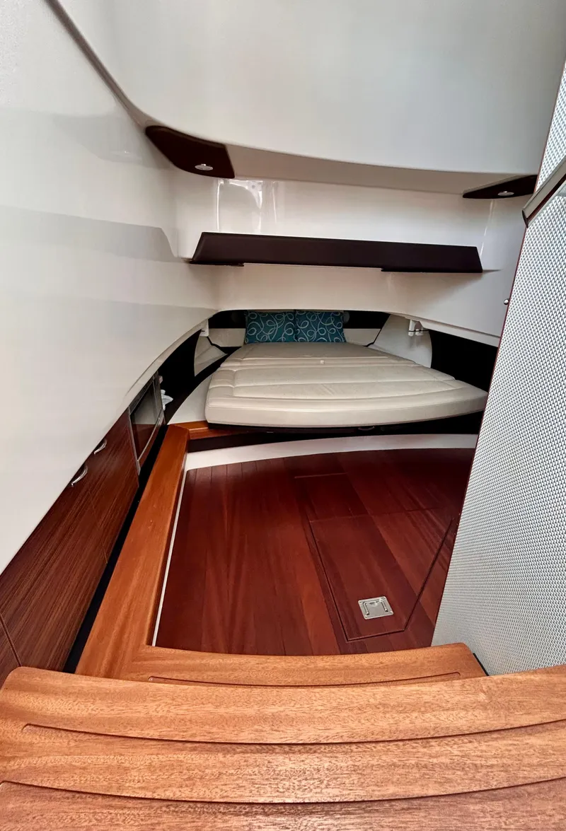 Slide: The Image of 2018 Pursuit S 368 Sport cabin interior with wooden flooring and a cozy bed. - 4