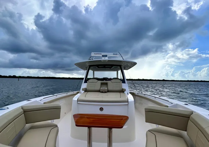 Slide: The Image of 2018 Pursuit S 368 Sport boat on water under dramatic cloudy sky. - 9