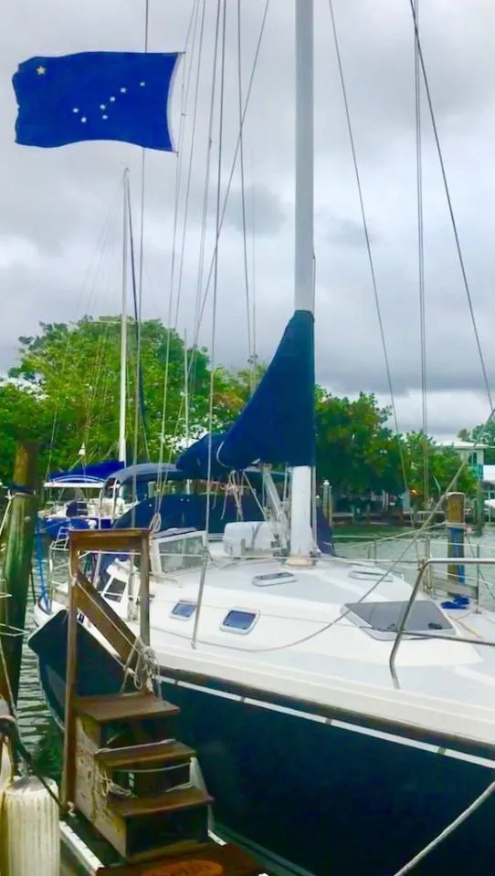Slide: The Image of Sailboat Catalina 42 MK 1, 1992, docked with blue flag, overcast sky. - 20