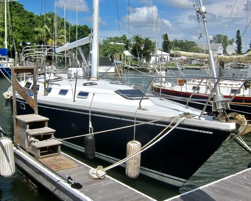 Slide: The Image of Sailboat Catalina 42 MK 1, 1992 model, docked at marina with lush greenery. - 23