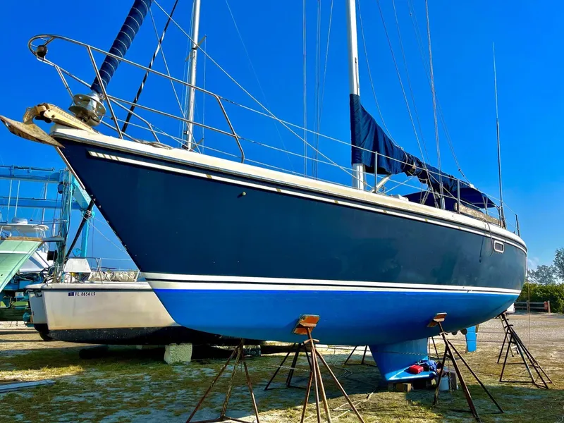 Slide: The Image of 1992 Catalina 42 MK 1 sailboat on stands, blue hull, clear sky background. - 4