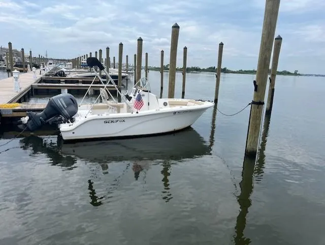Slide: The Image of 2016 Sea Fox 186 Commander boat docked at marina with calm water and cloudy sky. - 12