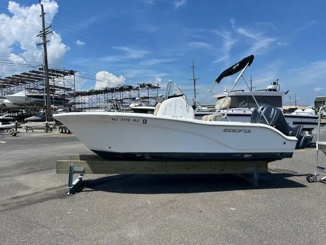 Slide: The Image of 2016 Sea Fox 186 Commander boat on display at a marina under a clear blue sky. - 17