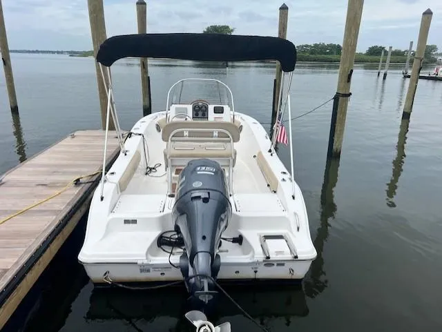 Slide: The Image of 2016 Sea Fox 186 Commander boat docked, featuring outboard motor and canopy. - 18