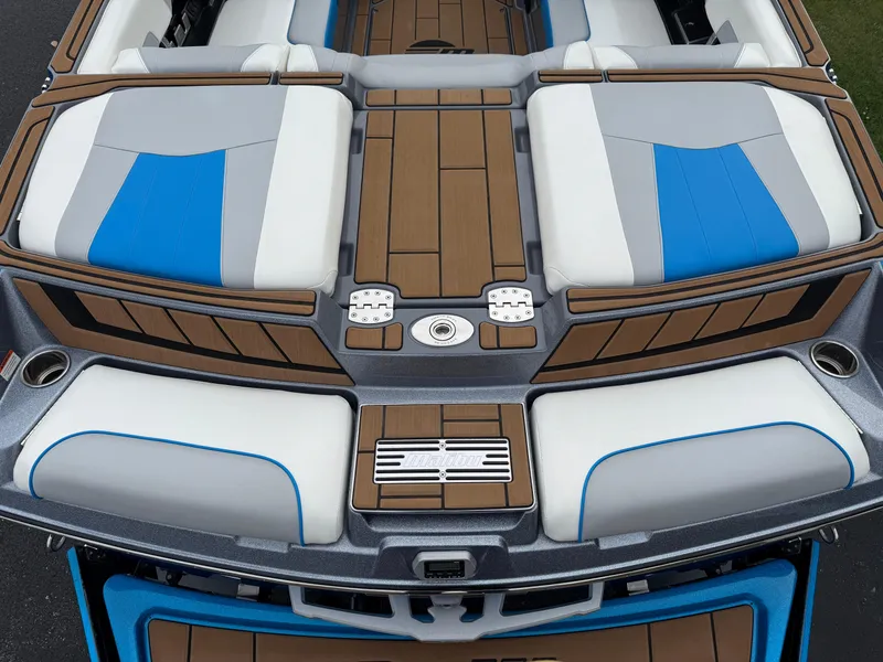 Slide: The Image of 2020 Malibu Wakesetter 23 MXZ boat interior with blue and gray seating, teak accents. - 12