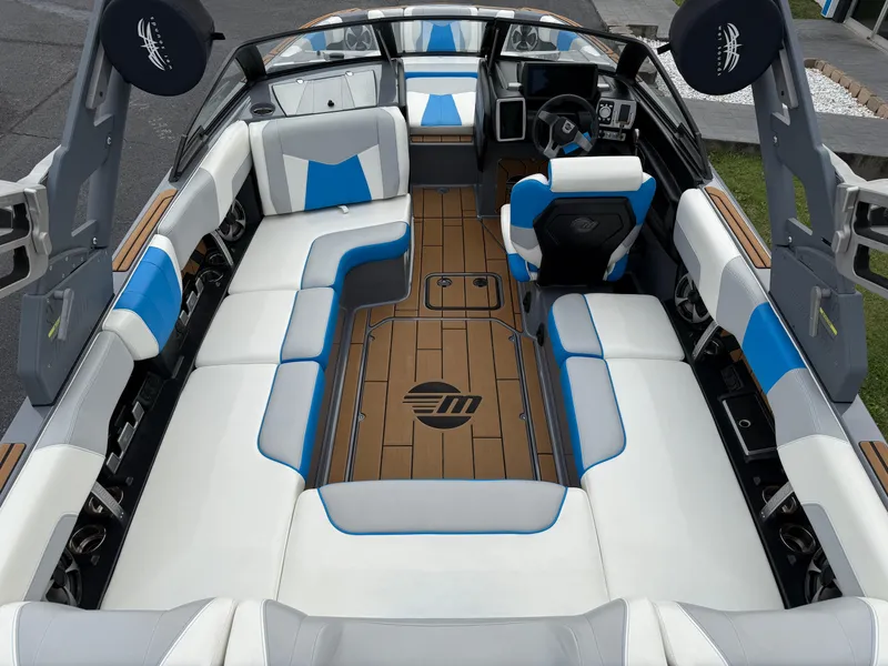 Slide: The Image of 2020 Malibu Wakesetter 23 MXZ interior with blue and white seating, modern dashboard, and spacious layout. - 14