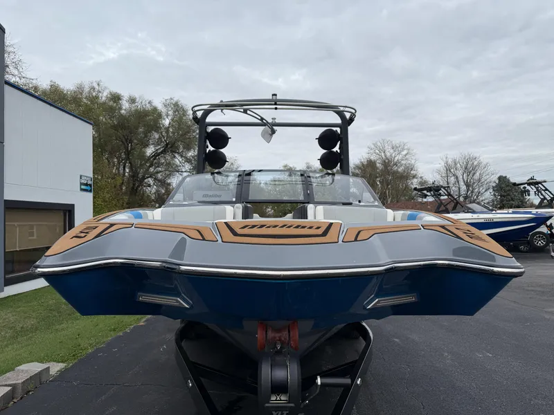 Slide: The Image of 2020 Malibu Wakesetter 23 MXZ boat, front view, parked outdoors on a cloudy day. - 2