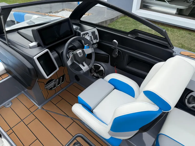 Slide: The Image of 2020 Malibu Wakesetter 23 MXZ interior with modern dashboard and blue-white seating. - 23