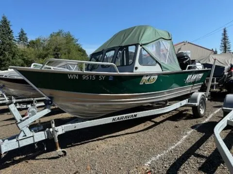 The Image of 2019 Klamath 19 GTX boat on Karavan trailer, green canopy, parked outdoors. - 0