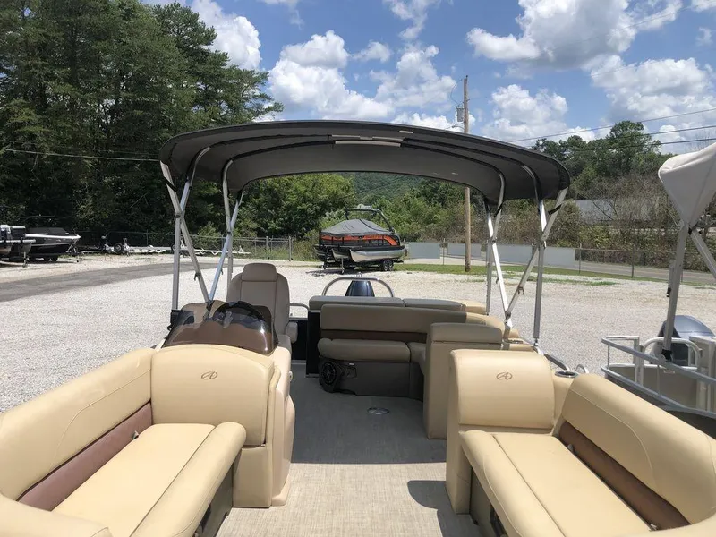 Slide: The Image of 2019 Avalon GS Cruise 23' pontoon boat with canopy, parked outdoors under a cloudy sky. - 3