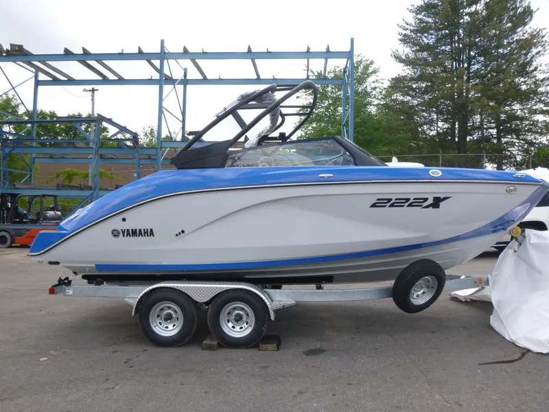 The Image of 2025 Yamaha Boats 222XD on trailer, blue and white design, parked outdoors. - 1