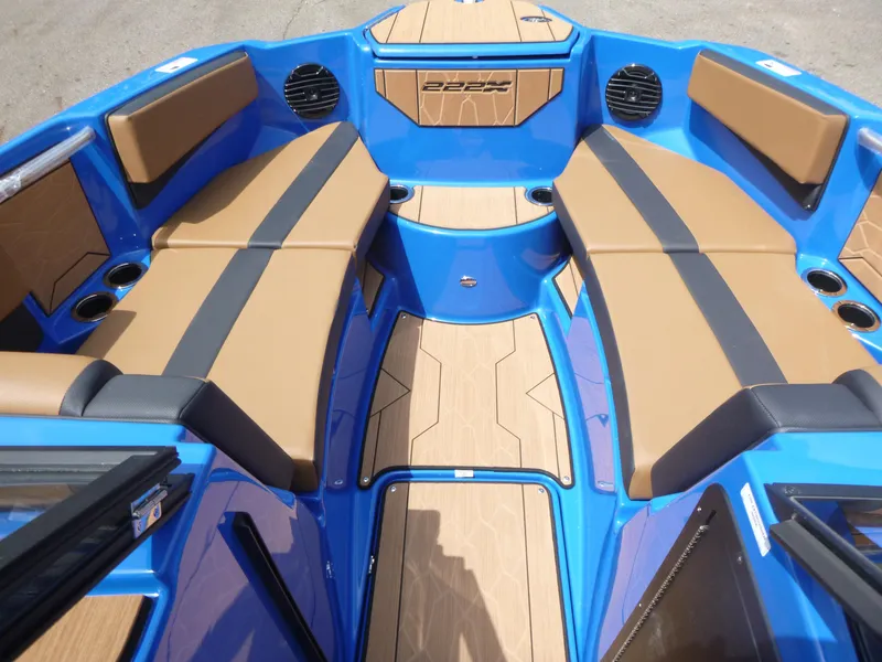 Slide: The Image of 2025 Yamaha Boats 222XD interior with blue and tan seating, cup holders, and sleek design. - 10
