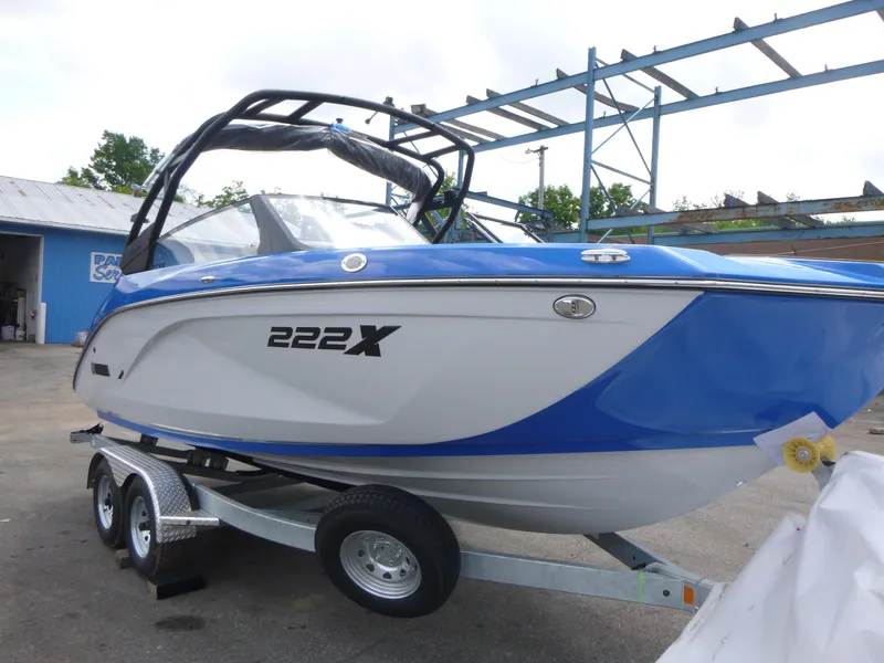 Slide: The Image of 2025 Yamaha Boats 222XD on trailer, blue and white design, parked outdoors. - 3