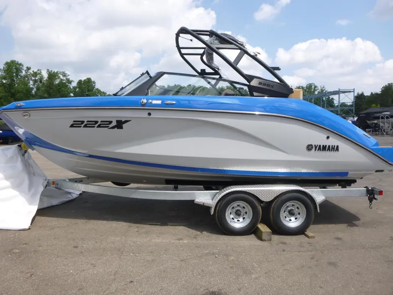 Slide: The Image of 2025 Yamaha Boats 222XD on trailer, blue and white design, parked outdoors. - 4