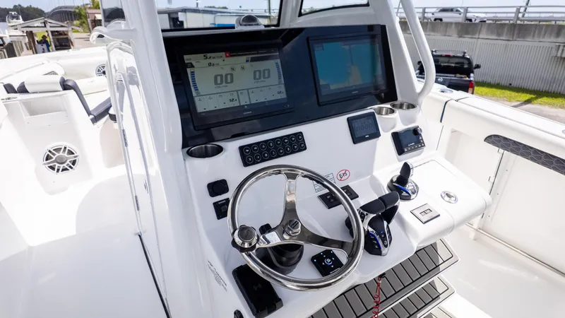 Slide: The Image of 2026 Tidewater 302CC boat dashboard with steering wheel, dual screens, and control panel. - 12