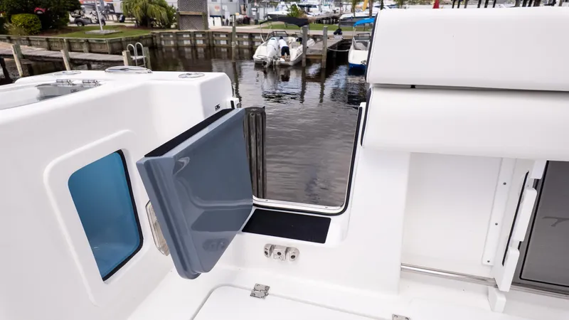 Slide: The Image of 2026 Tidewater 302CC boat with open side door, docked at marina. - 15