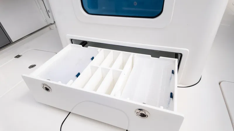Slide: The Image of Tidewater 302CC 2026 boat storage drawer with compartments, open on deck. - 17
