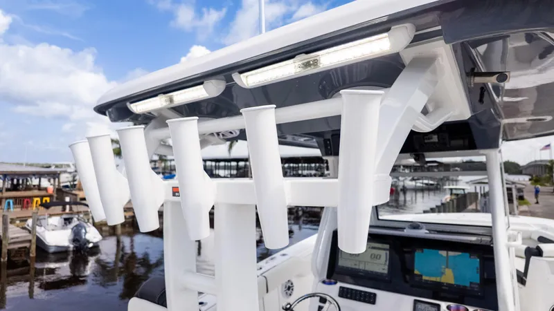 Slide: The Image of 2026 Tidewater 302CC boat with rod holders and navigation equipment at a marina. - 18