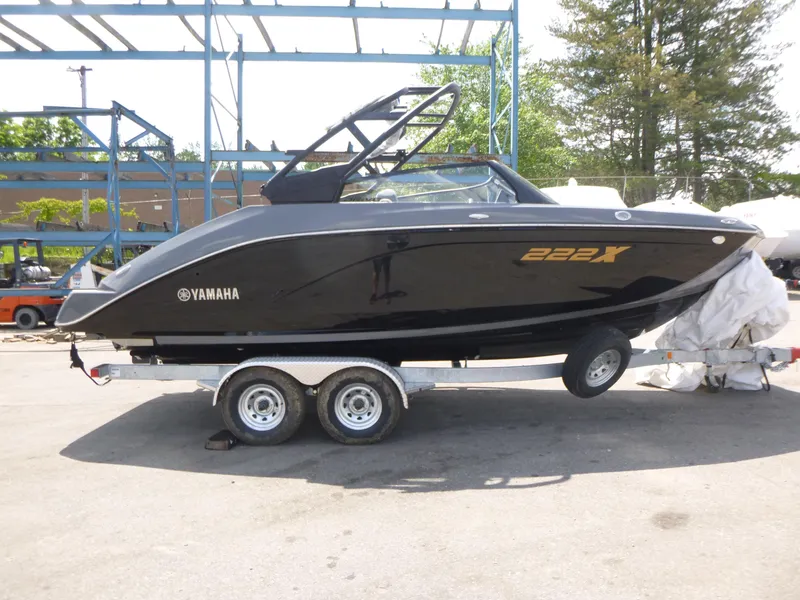 The Image of 2025 Yamaha Boats 222XD on trailer, sleek black design, parked outdoors. - 1