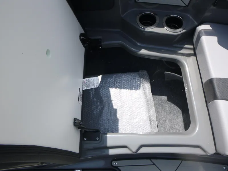 Slide: The Image of Open storage compartment in 2025 Yamaha Boats 222XD with cup holders. - 11