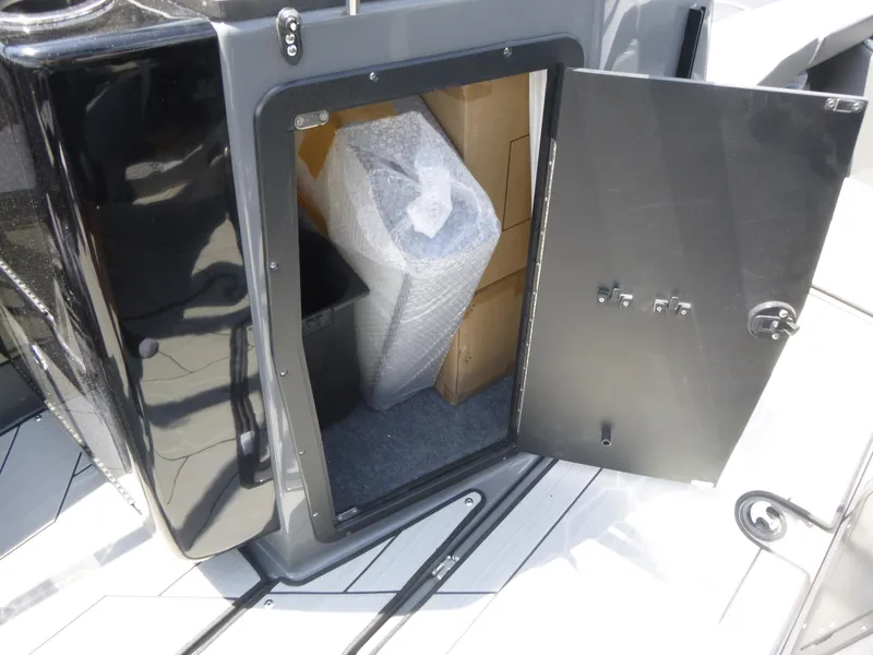 Slide: The Image of Open storage compartment on 2025 Yamaha Boats 222XD, showing interior with packaged items. - 14