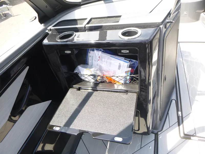 Slide: The Image of 2025 Yamaha Boats 222XD storage compartment with cup holders and open hatch. - 9