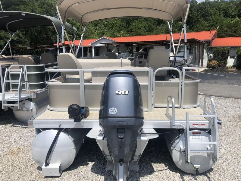 Slide: The Image of 2024 Bennington 20 SF pontoon boat with 90 HP engine, docked outdoors. - 6