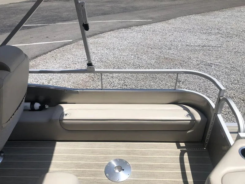 Slide: The Image of 2024 Bennington 20 SF boat interior with beige seating and metal railing. - 7