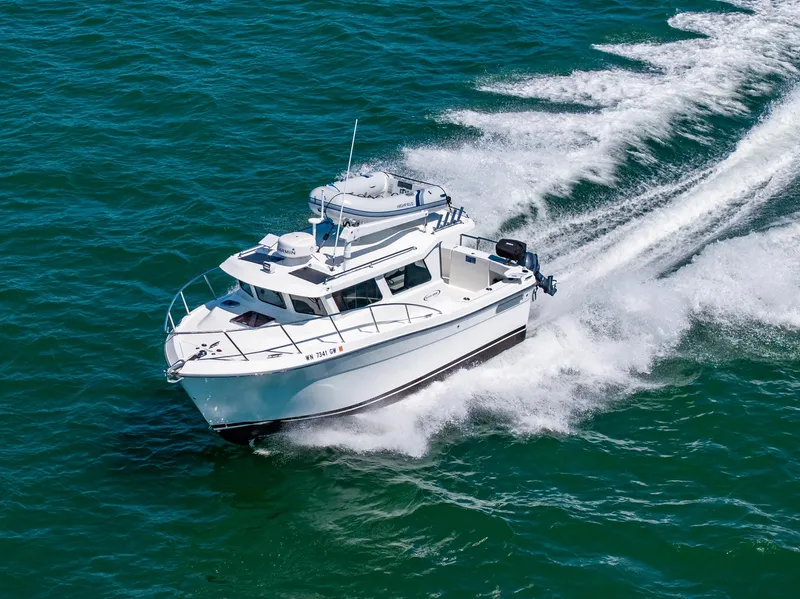 The Image of 2021 Ocean Sport 26/27 boat cruising on open water, creating a dynamic wake. - 0