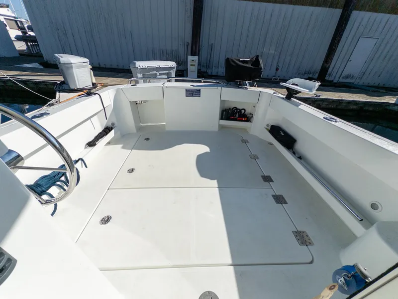 Slide: The Image of 2021 Ocean Sport 26/27 boat deck with storage compartments and steering wheel. - 12